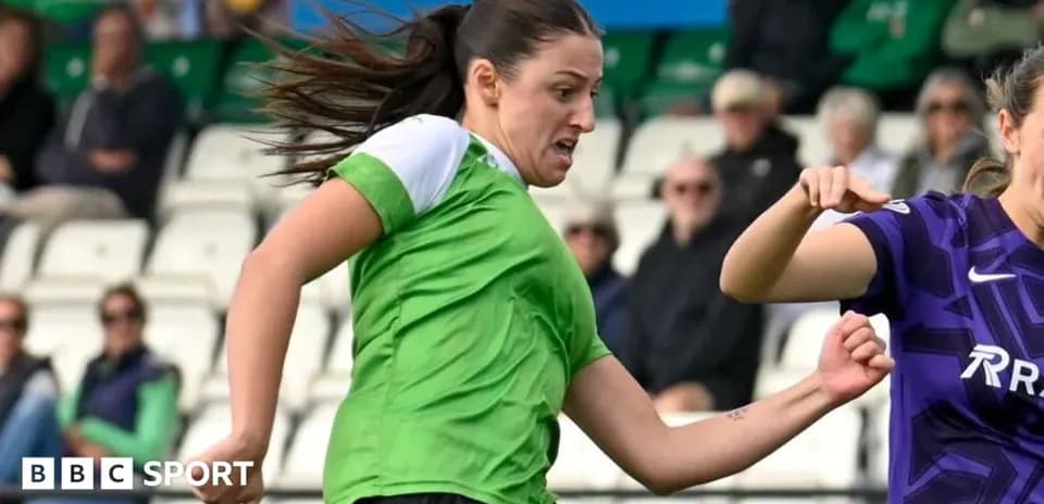 Joueuse en vert dribblant le ballon pendant un match