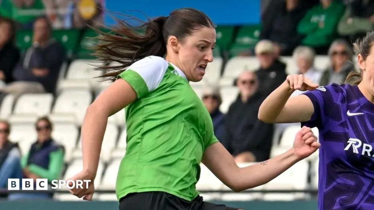 Joueuse en vert dribblant le ballon pendant un match