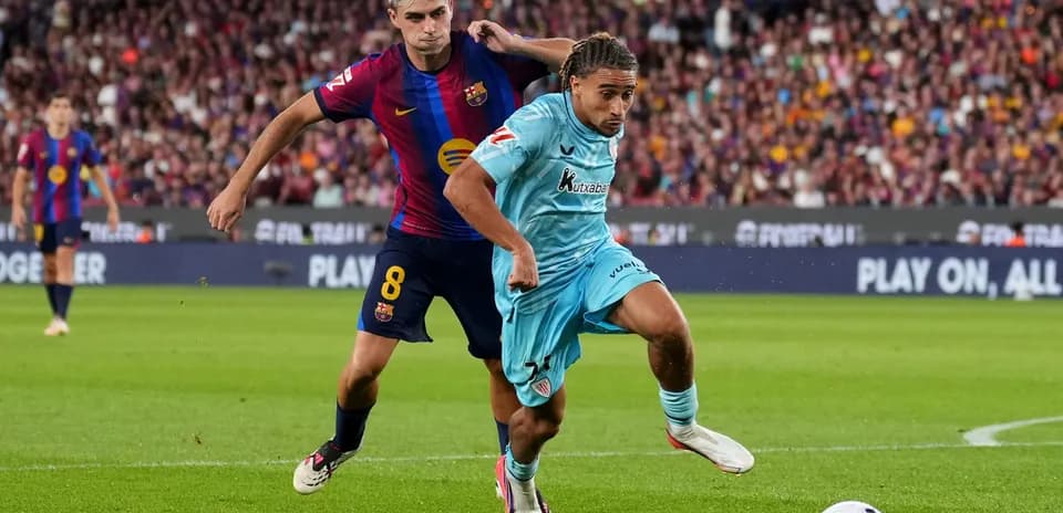 Joueur de Barcelone poursuivant un adversaire avec le ballon