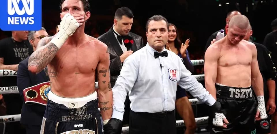 Boxeurs après le combat avec l'arbitre au centre