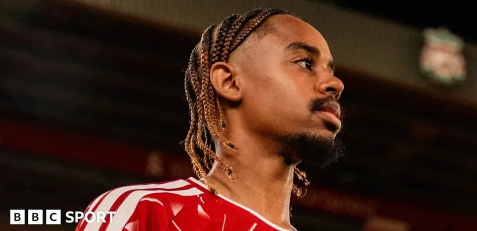 Joueur portant un maillot rouge, regardant au loin