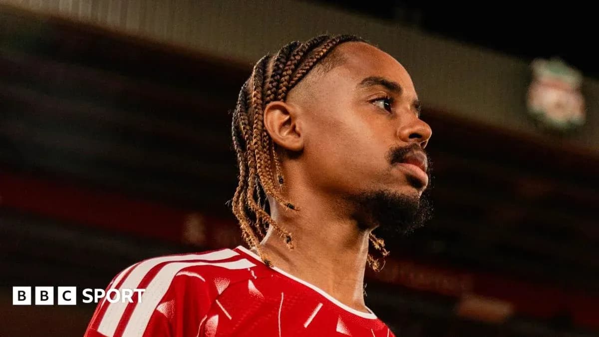 Joueur portant un maillot rouge, regardant au loin