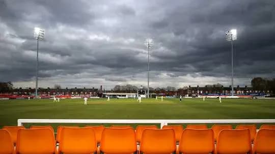 Match de cricket sous un ciel nuageux avec spectateurs