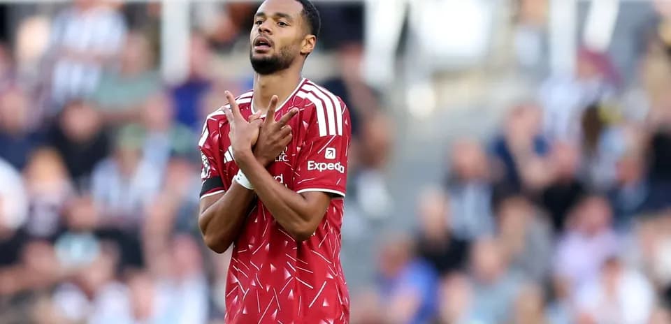 Joueur en maillot rouge faisant un geste sur le terrain