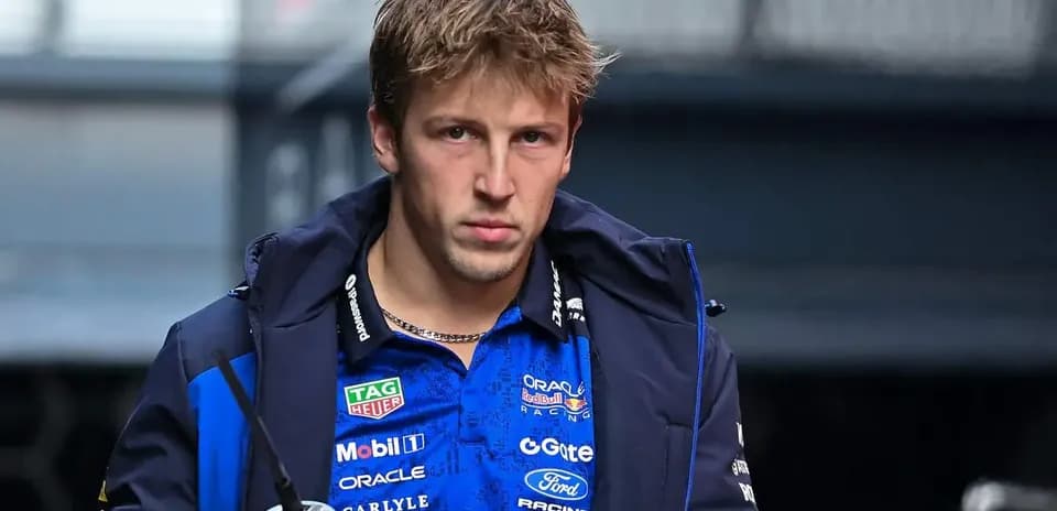 Pilote entrant dans le paddock avec une boisson