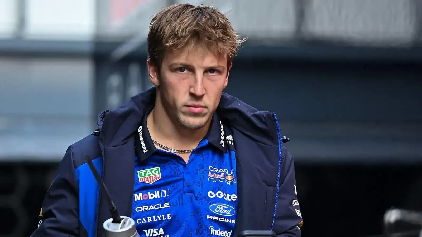 Pilote entrant dans le paddock avec une boisson