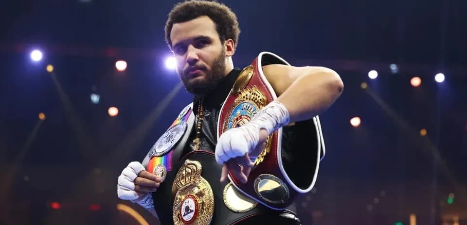 Boxeur avec plusieurs ceintures de champion sur scène