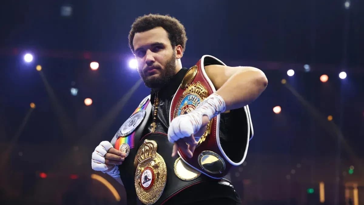 Boxeur avec plusieurs ceintures de champion sur scène
