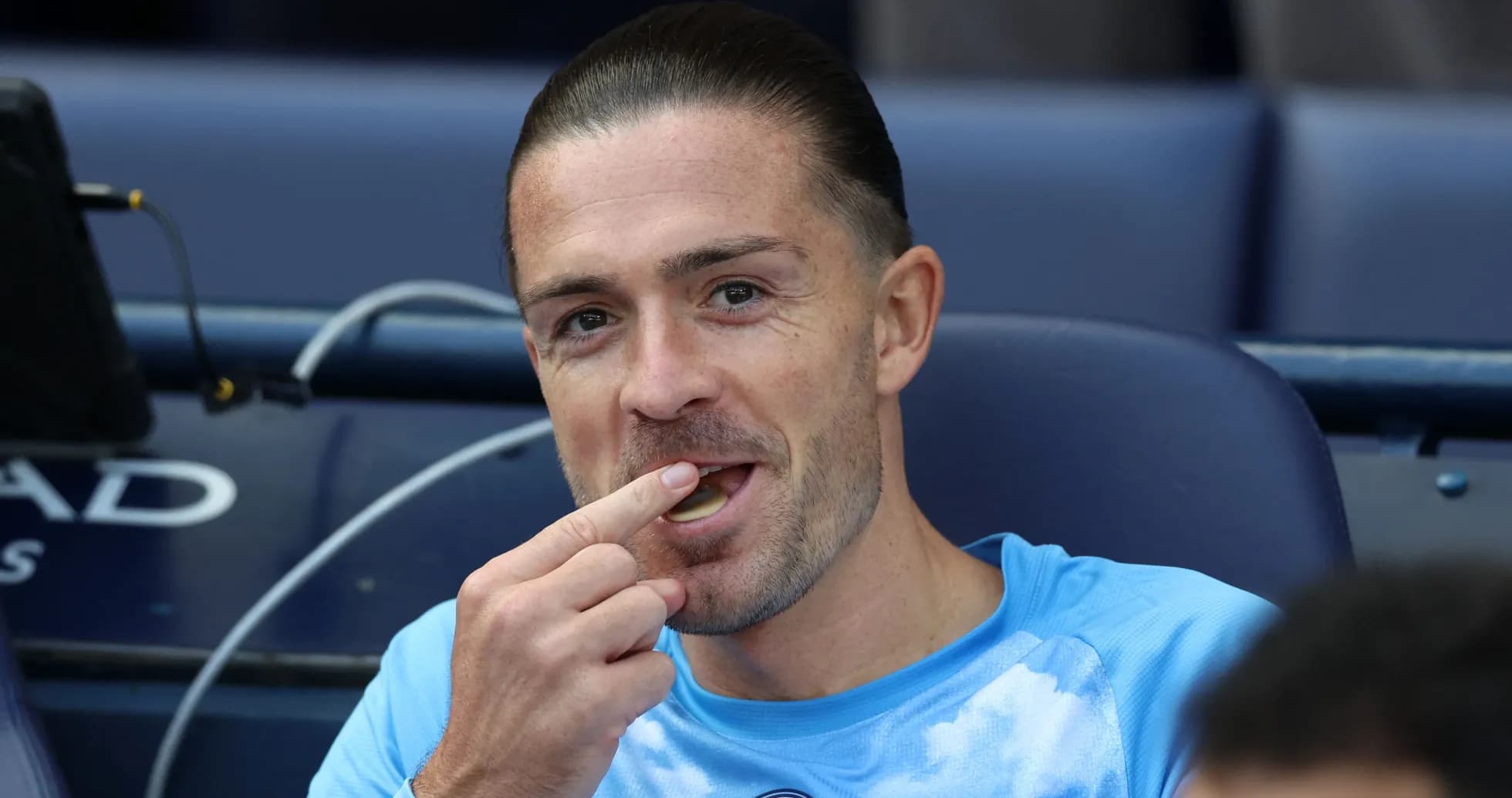 Joueur assis sur le banc, mangeant une sucrerie