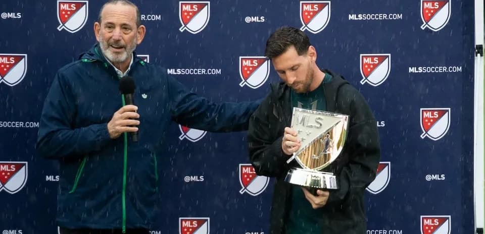 Messi holding MLS trophy during press conference