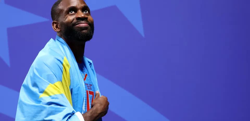 Athlete wearing national flag, looking upward