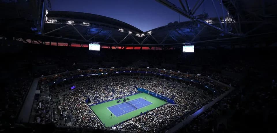 Stade plein lors d'un match de tennis au crépuscule