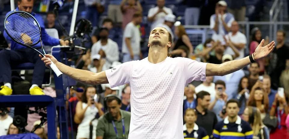 Joueur levant les bras en signe de victoire au tennis