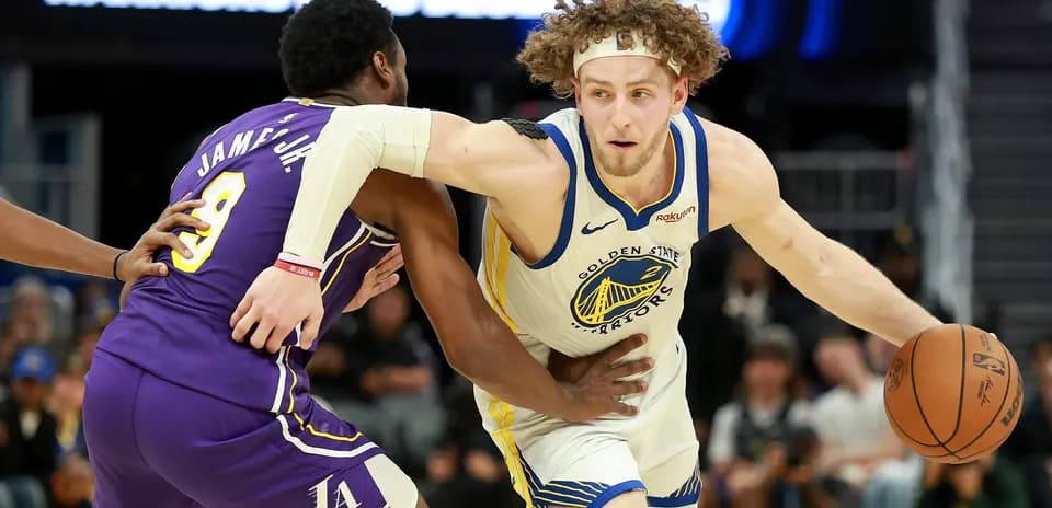 Joueur des Warriors dribblant sous pression d'un adversaire