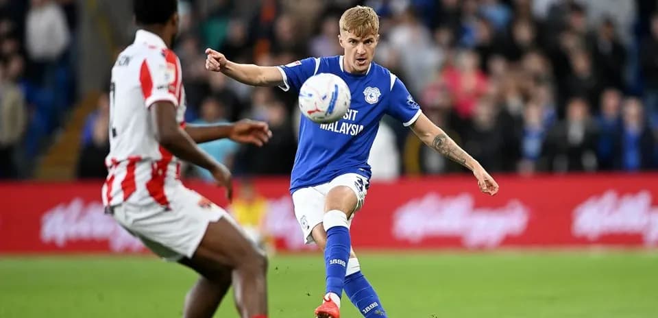 Joueur en bleu tirant le ballon pendant un match