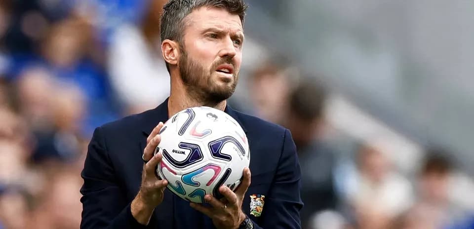 Entraîneur tenant un ballon sur le bord du terrain