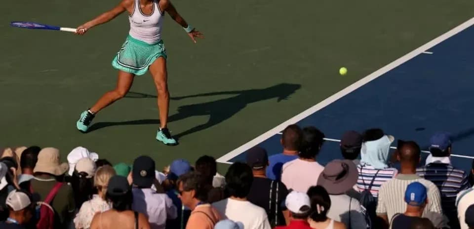 Joueuse de tennis frappant la balle devant un public