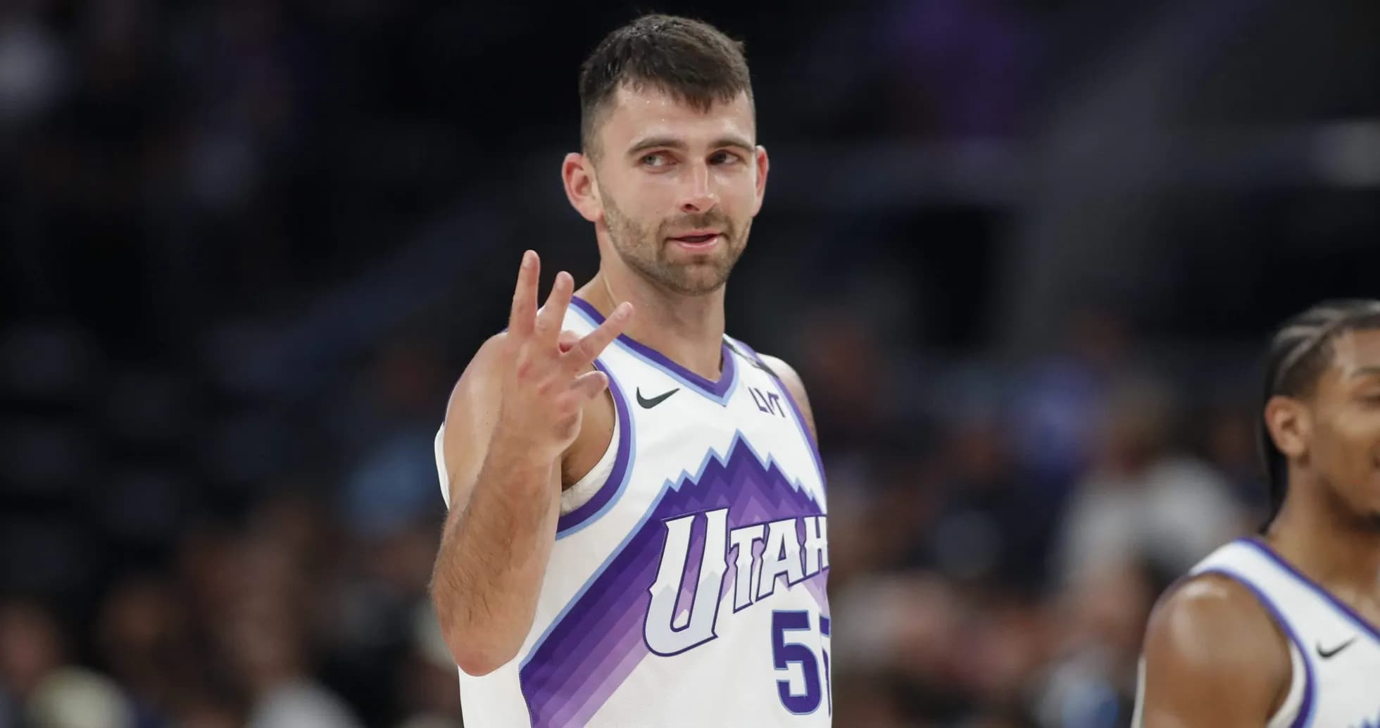 Joueur de basket montrant trois doigts sur le terrain