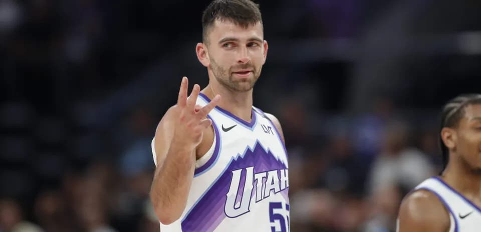 Joueur de basket montrant trois doigts sur le terrain