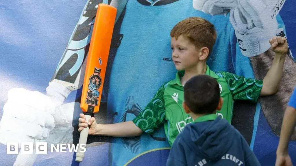 Enfant avec une batte de cricket posant fièrement