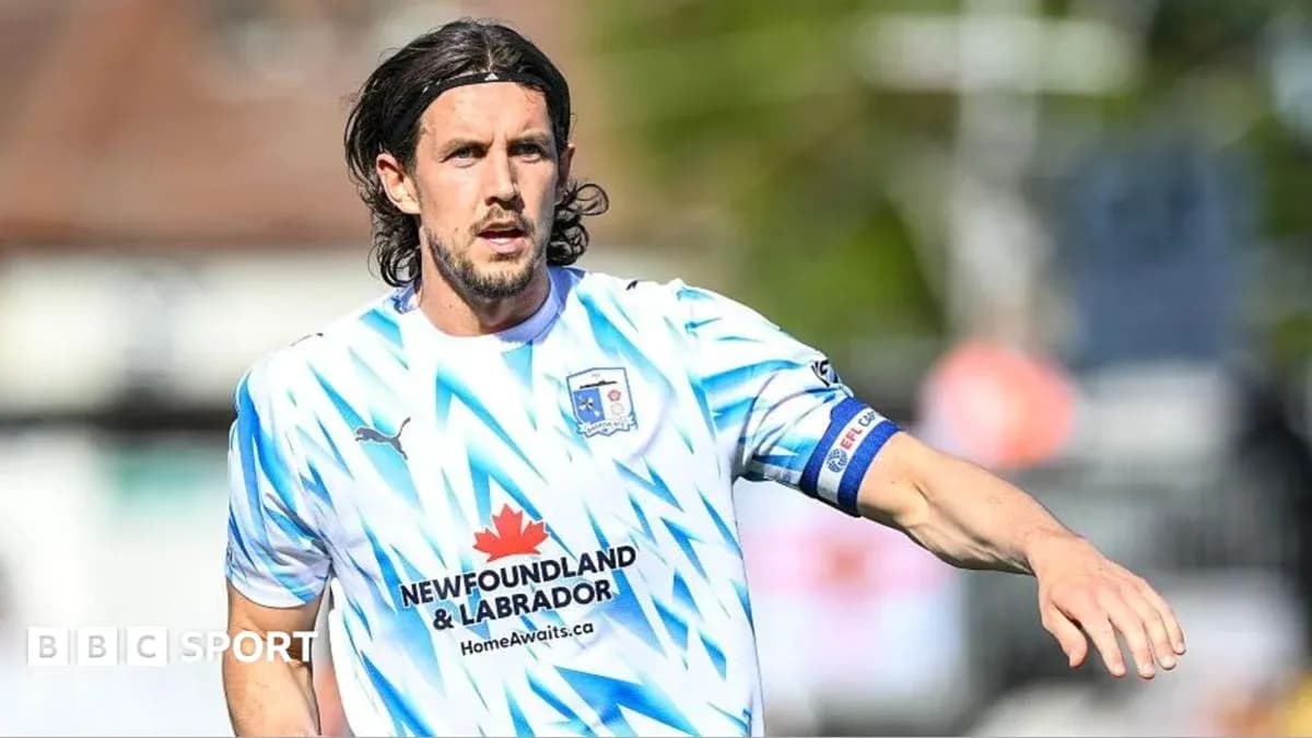 Joueur en maillot clair courant sur le terrain