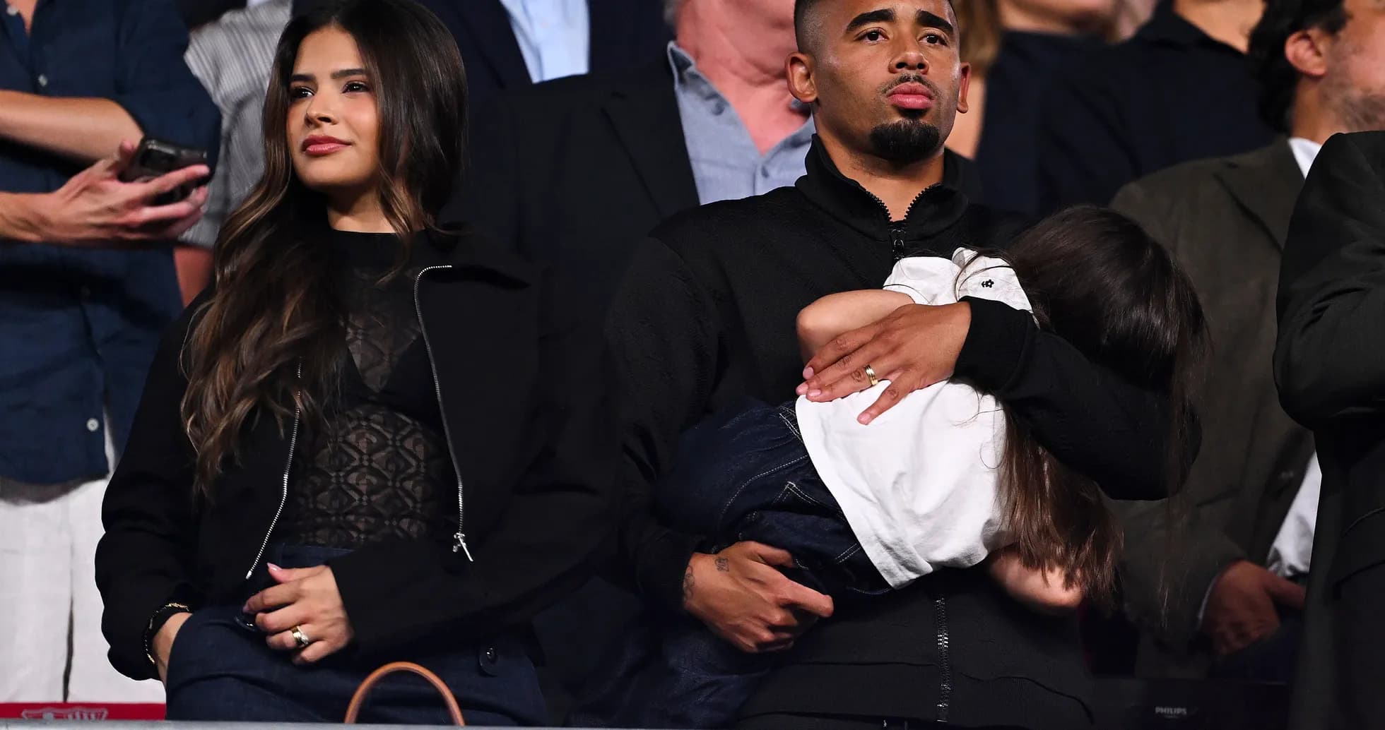 Couple with child watching an event in the stands