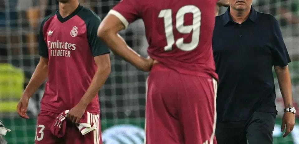 Deux joueurs du Real Madrid et un entraîneur sur le terrain