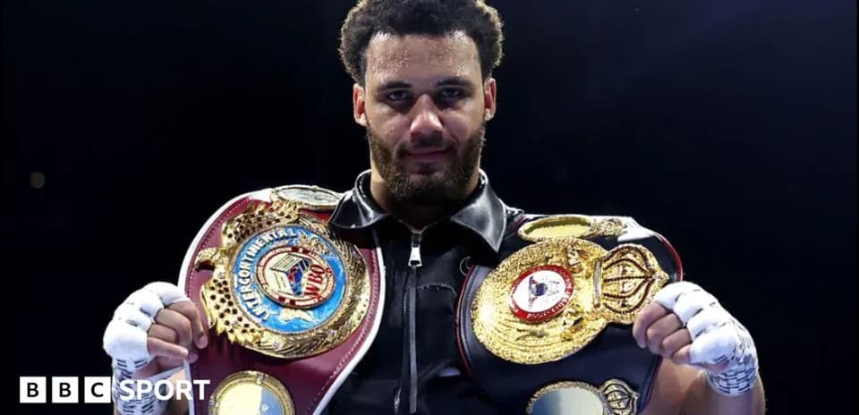 Boxeur tenant deux ceintures de champion dans le ring
