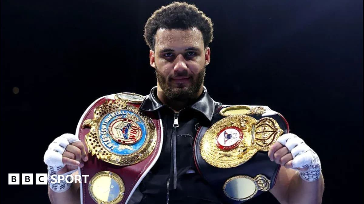 Boxeur tenant deux ceintures de champion dans le ring
