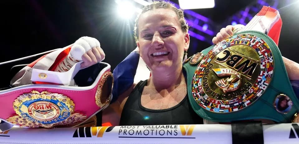 Boxeuse tenant des ceintures de championne après le combat