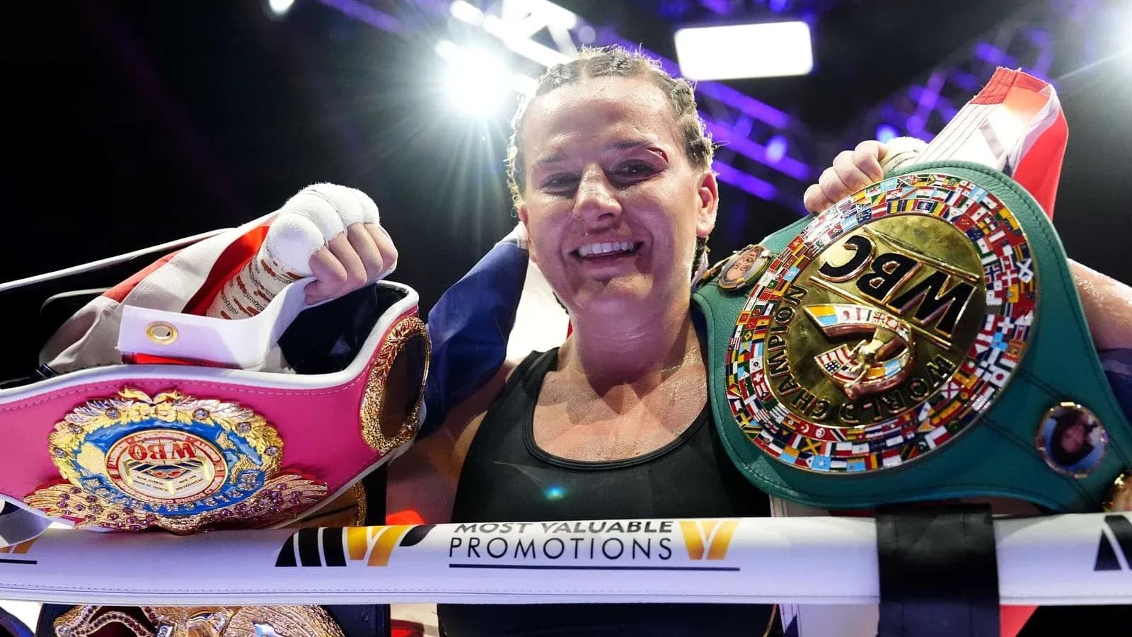Boxeuse tenant des ceintures de championne après le combat