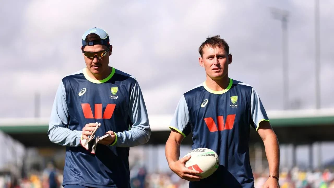 Deux joueurs de cricket marchant sur le terrain