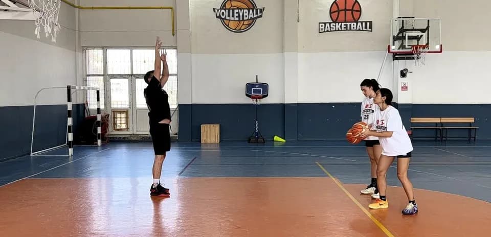 Joueur tirant au basket avec deux coéquipières