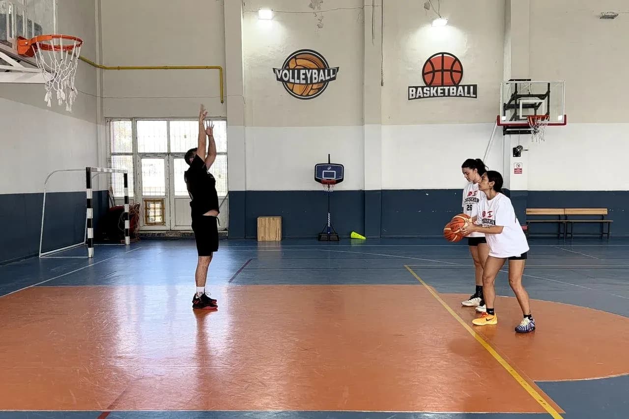 Joueur tirant au basket avec deux coéquipières