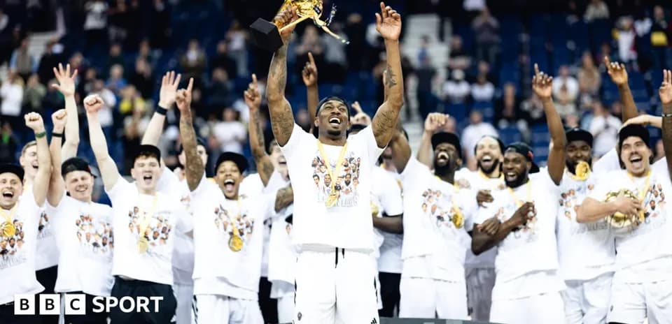 Joueur levant le trophée avec l'équipe célébrant