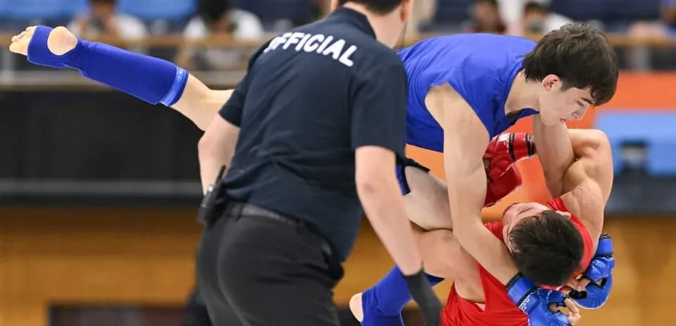 Lutte entre deux combattants, l'arbitre observant
