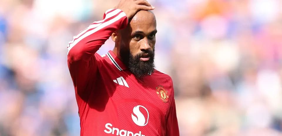 Joueur de Manchester United touchant sa tête sur le terrain
