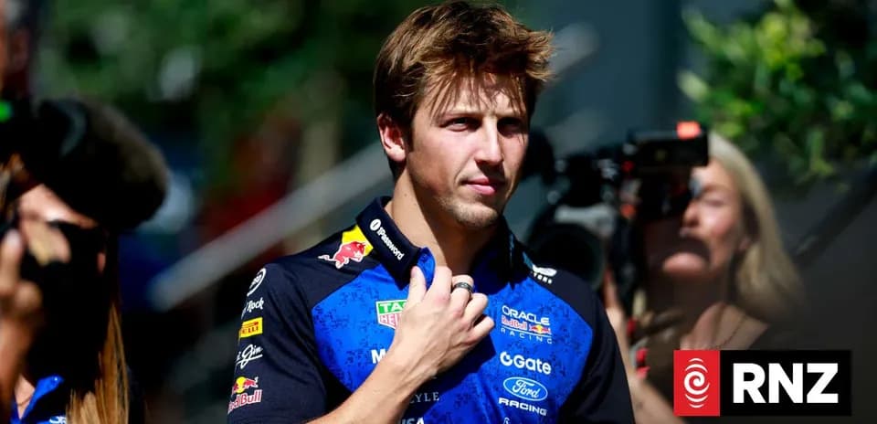 Pilote en tenue de course devant des caméras