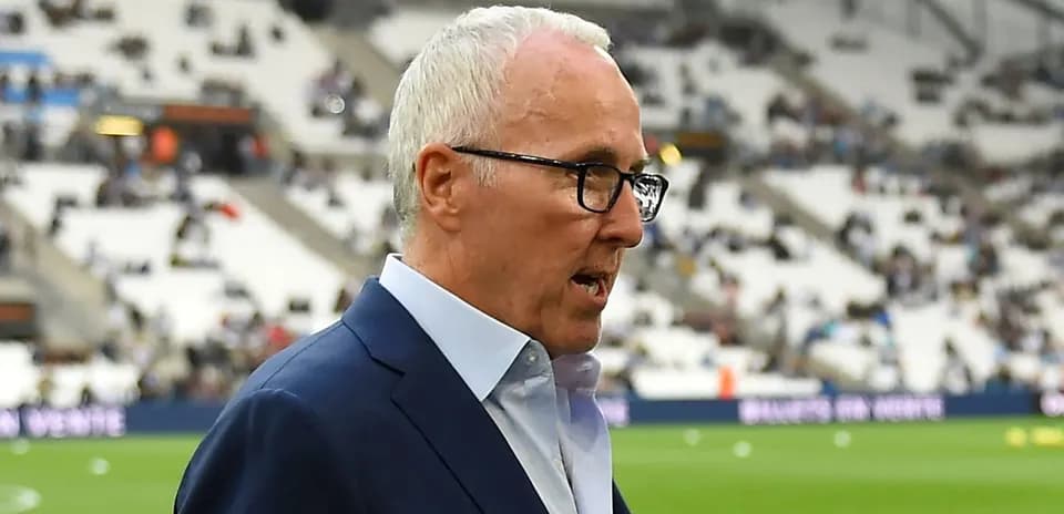 Homme en costume marchant près du terrain de football