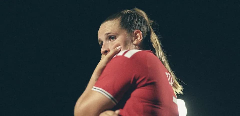 Joueuse de football en maillot rouge, pensive