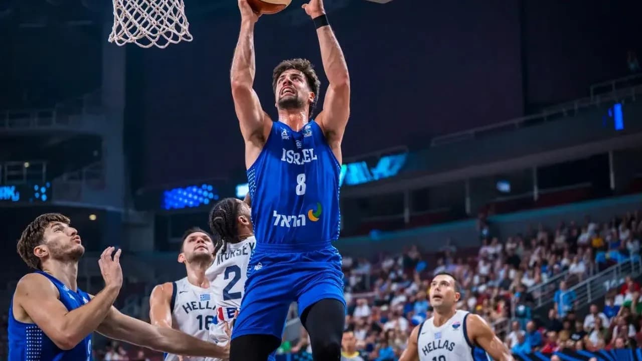 Joueur israélien dunkant pendant un match de basket