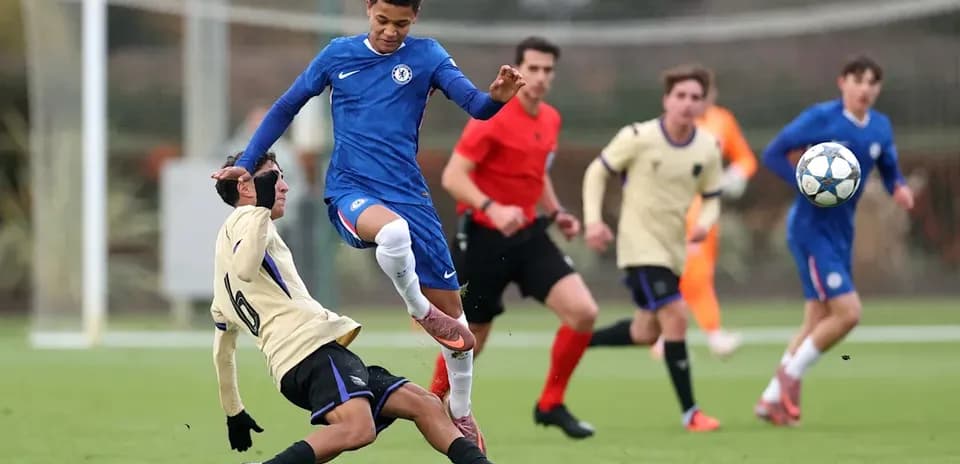 Joueur de Chelsea dribblant un adversaire au sol
