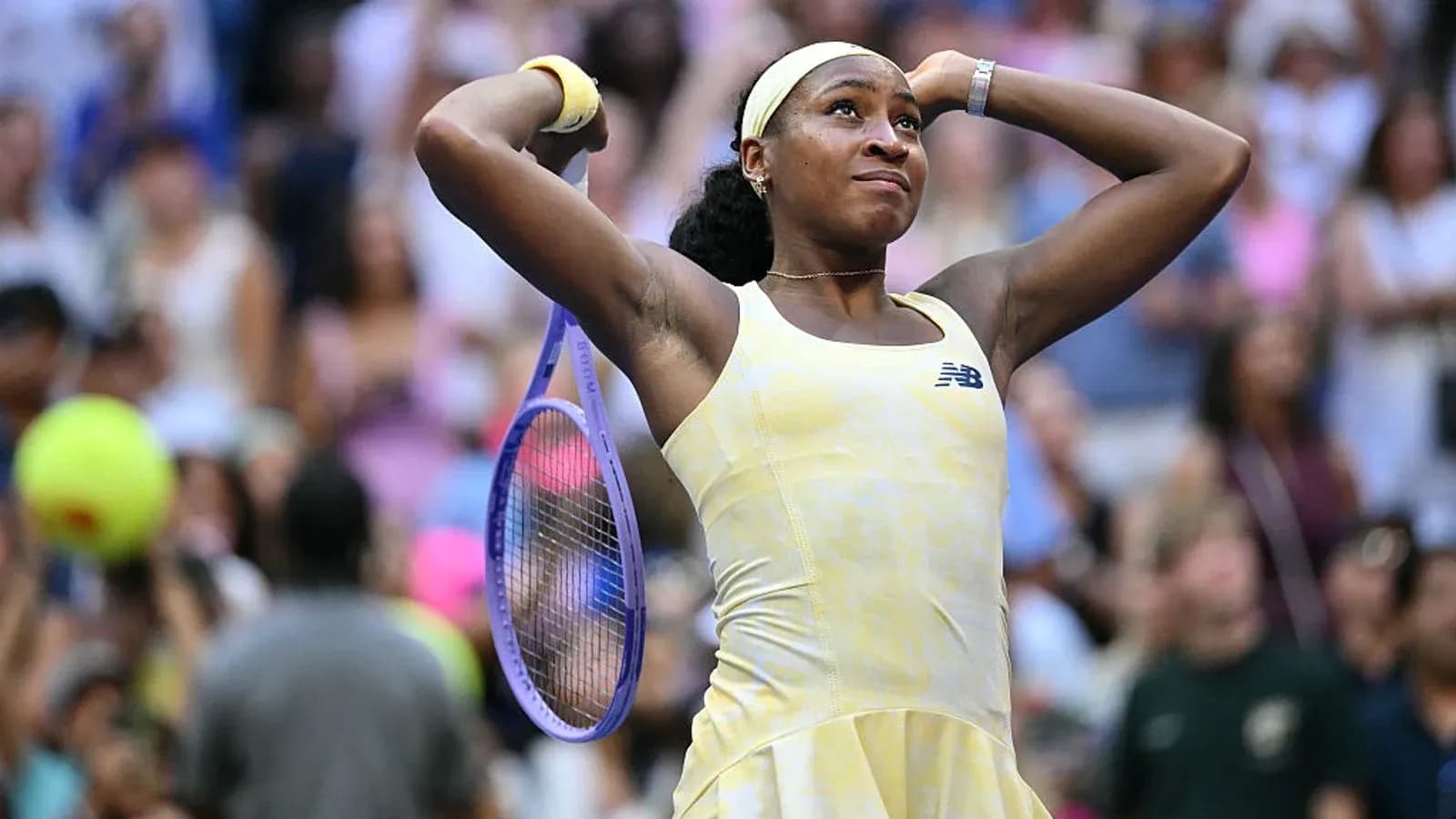 Joueuse levant les bras avec une raquette de tennis