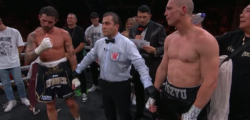 Boxeurs et arbitre dans le ring après le match