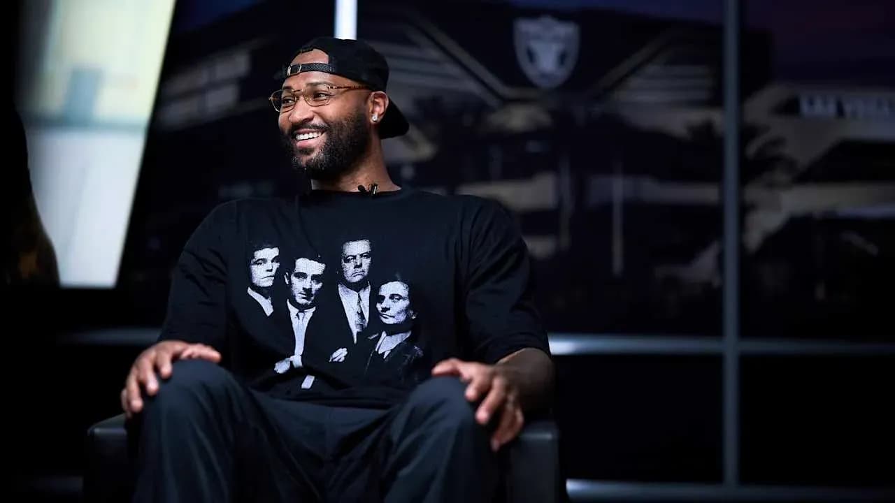 Homme souriant portant un t-shirt noir assis