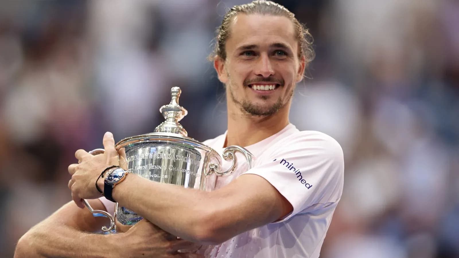 Joueur tenant le trophée de tennis avec sourire