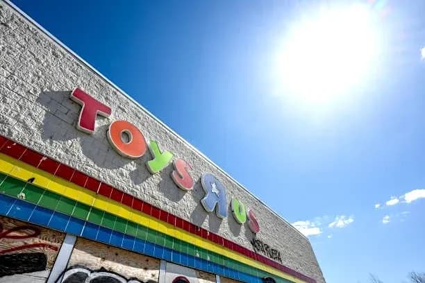 Enseigne colorée de Toys R Us sous un ciel bleu