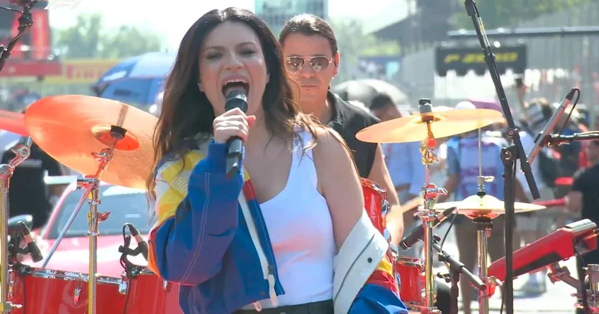 Chanteuse performe sur scène avec batteur en arrière-plan