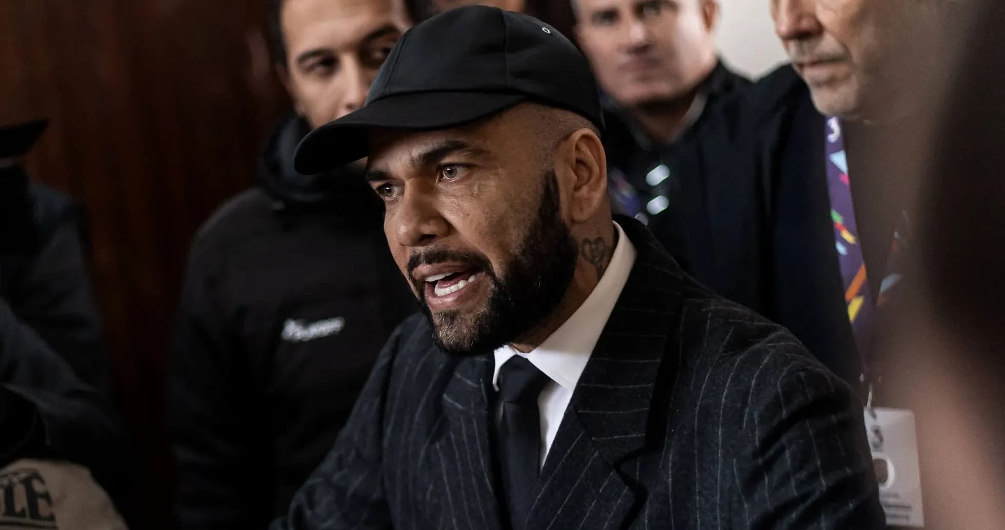 Homme en costume parlant devant un groupe de personnes