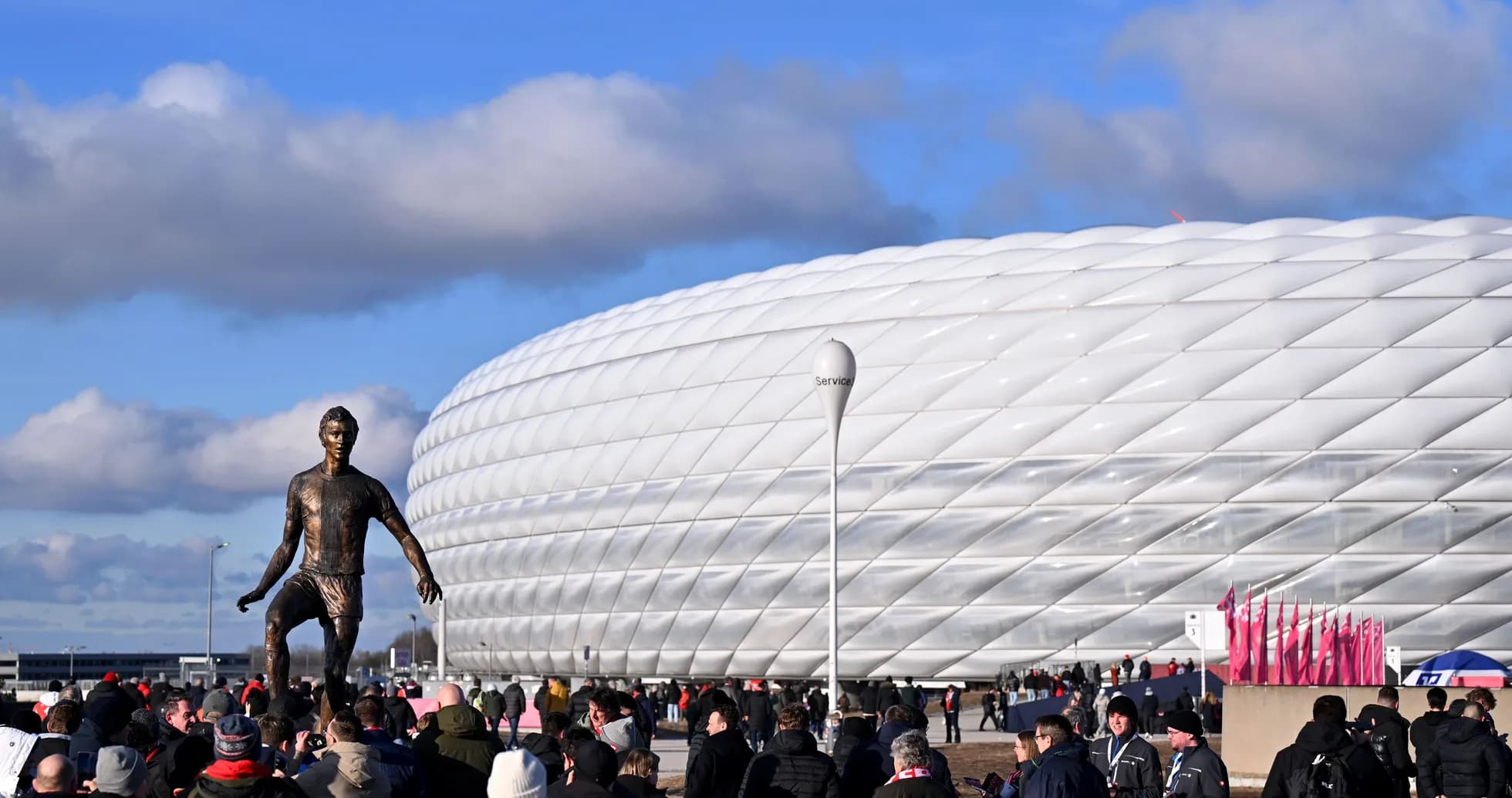 Statue of player outside stadium with fans